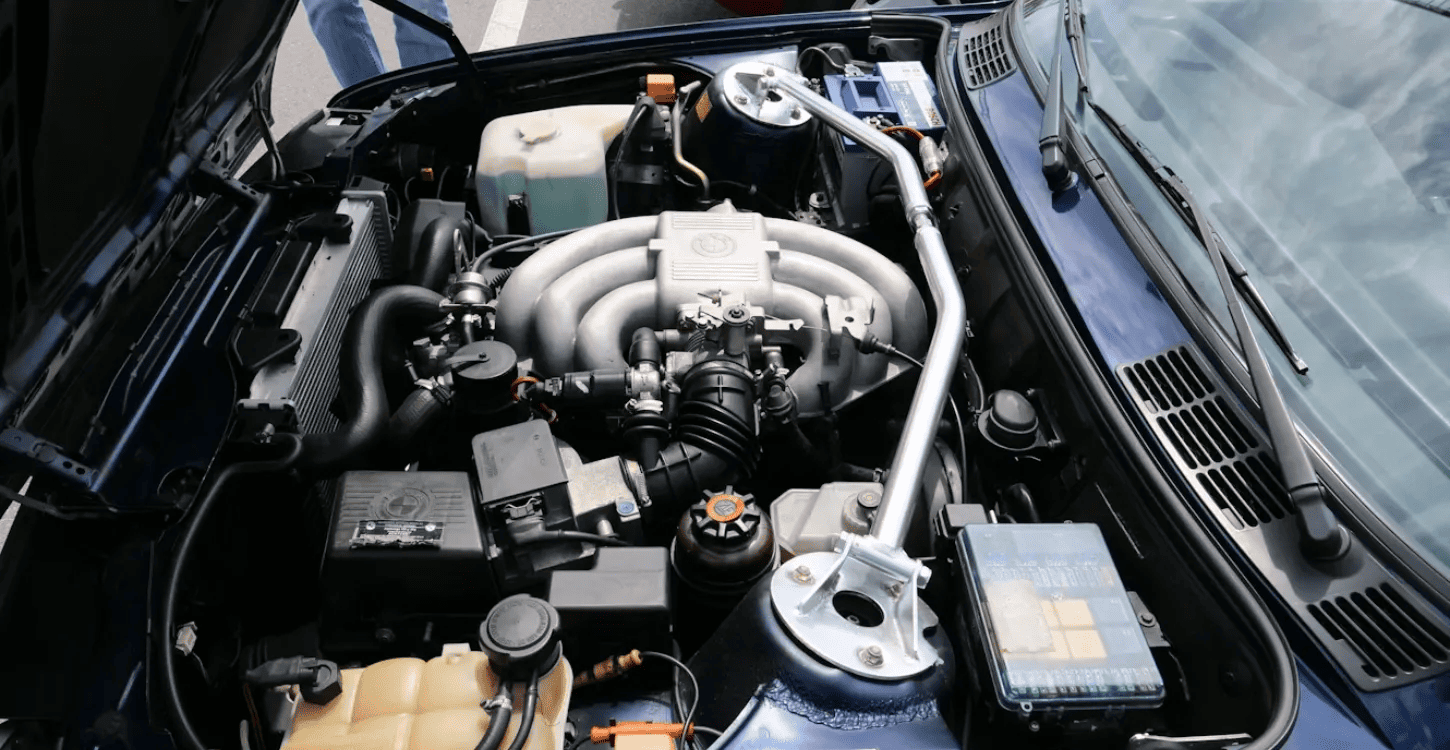 Car engine bay showing the cooling system as part of overall engine temperature control