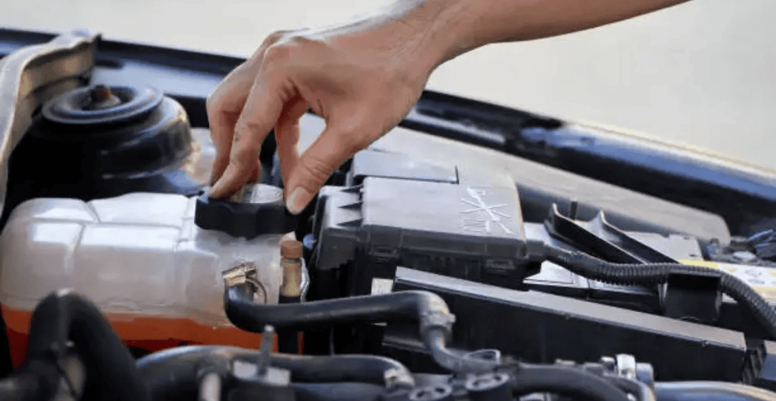 Opening the coolant reservoir cap during a cooling system flush and refill as part of routine engine maintenance